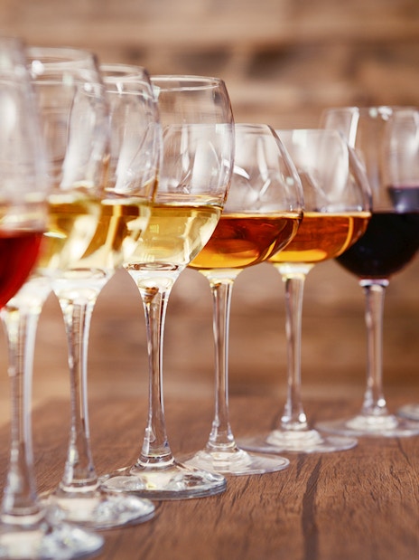 Wine glasses lined up on a wooden table, part of a Krka National Park tour from Split.