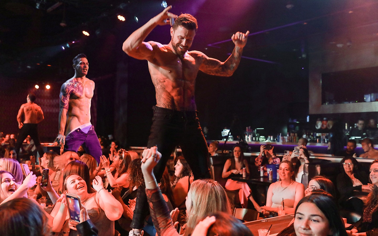 Performers on stage at Australia's Thunder from Down Under show, entertaining an audience.