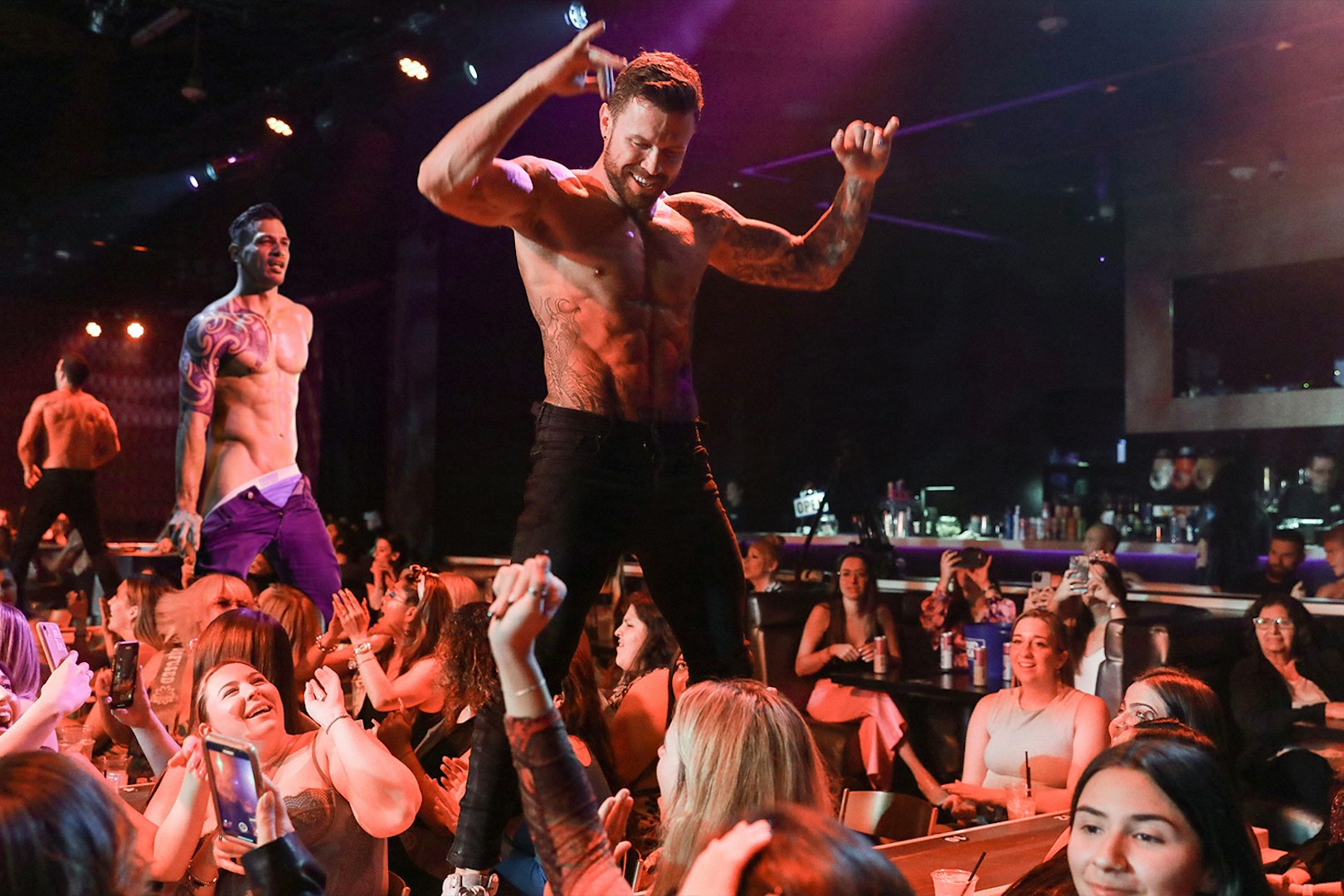 Performers on stage at Australia's Thunder from Down Under show, entertaining an audience.