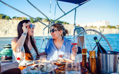 Guests enjoying drinks and snacks on a boat during Blue Cave Swim Stop & Three Island Tour.