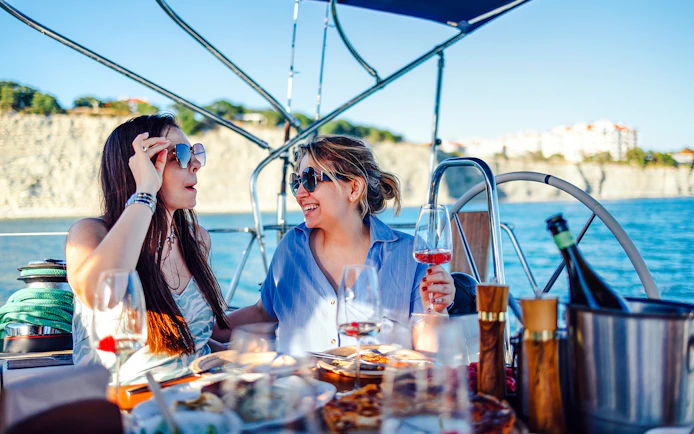 Guests enjoying drinks and snacks on a boat during Blue Cave Swim Stop & Three Island Tour.
