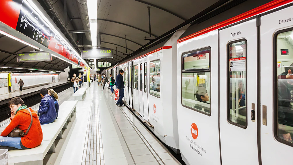 Tourists using Hola Barcelona Travel Card at a Barcelona metro station.