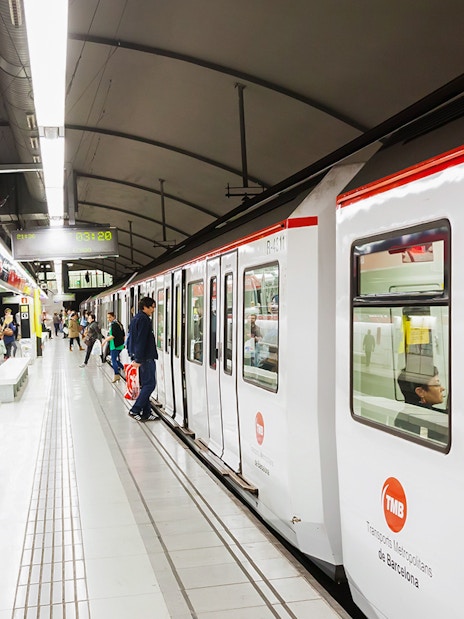 Tourists using Hola Barcelona Travel Card at a Barcelona metro station.