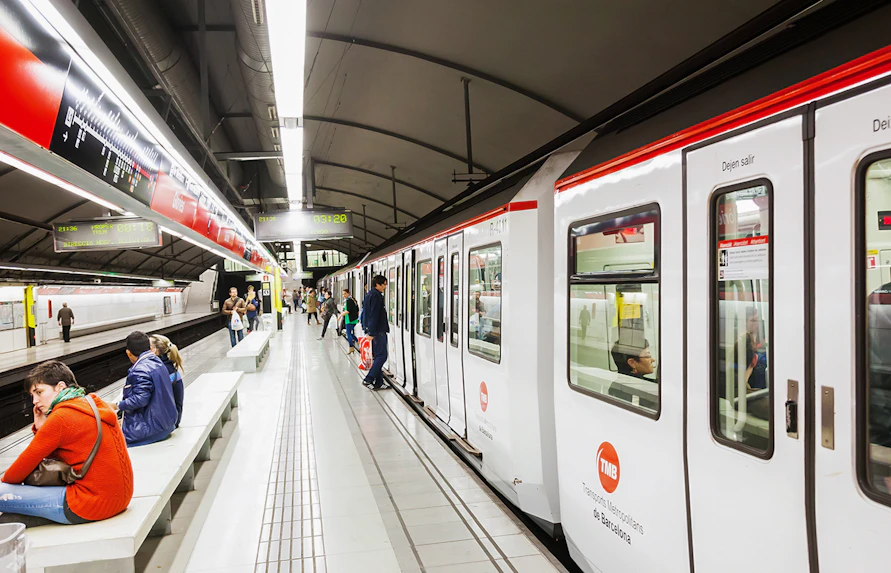 Tourists using Hola Barcelona Travel Card at a Barcelona metro station.