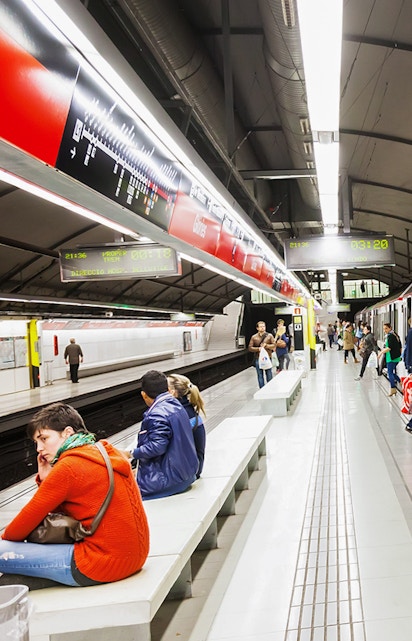 Tourists using Hola Barcelona Travel Card at a Barcelona metro station.