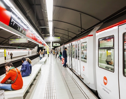 Tourists using Hola Barcelona Travel Card at a Barcelona metro station.