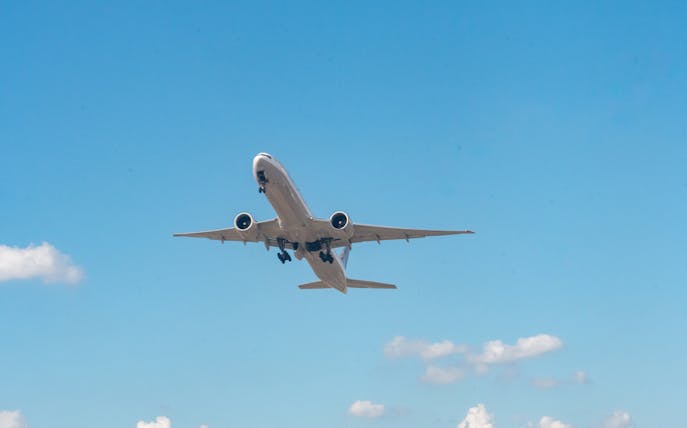 Airplane taking off from Newark Liberty International Airport against blue sky.