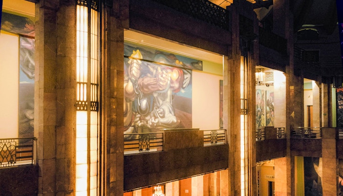 Interior view of Palacio de Bellas Artes upper floor showcasing intricate murals and architectural details in Mexico City.