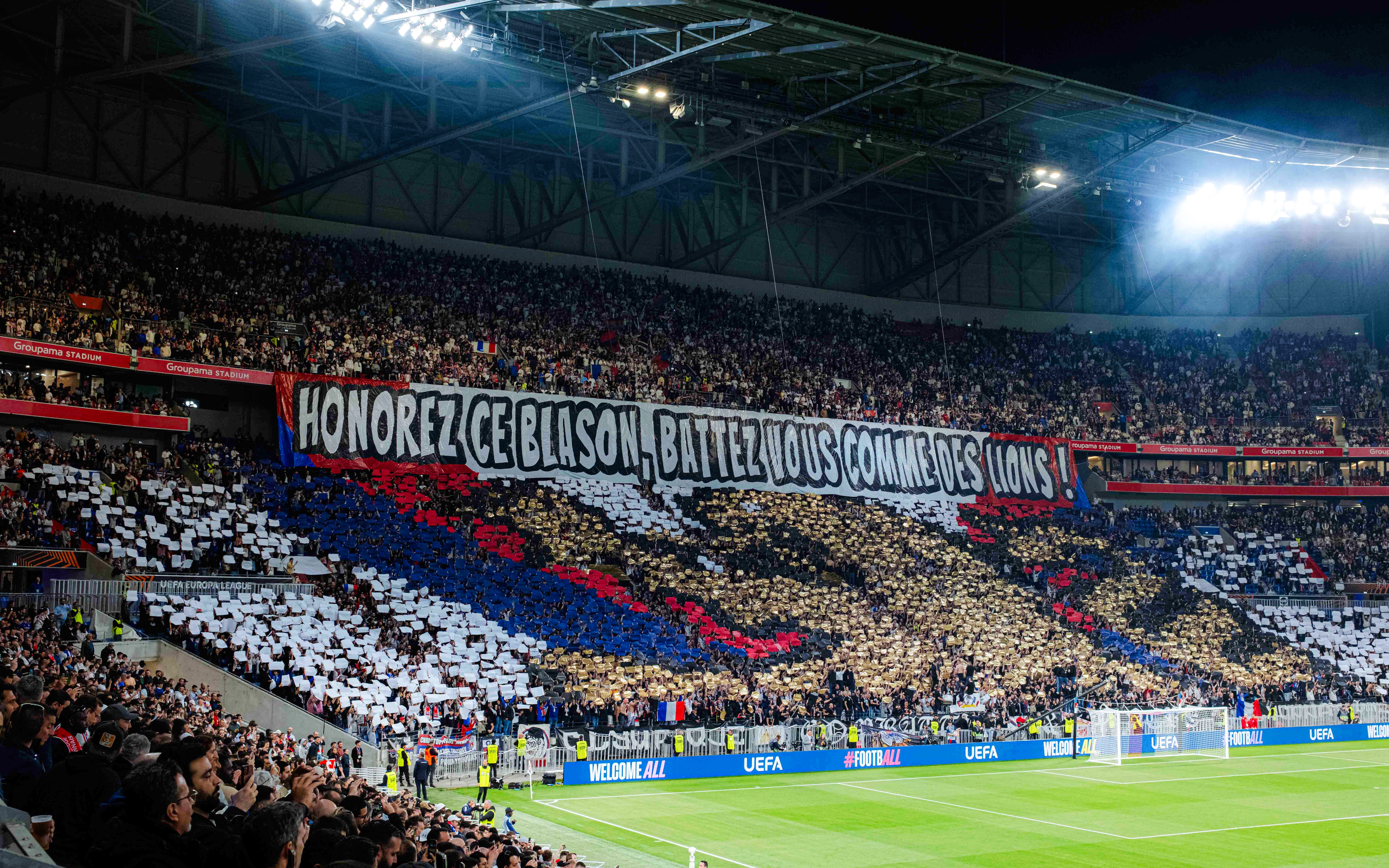 Crowd displaying a large banner at Olympique Lyonnais stadium, Lyon, France.