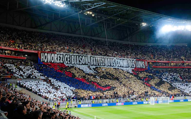 Crowd displaying a large banner at Olympique Lyonnais stadium, Lyon, France.