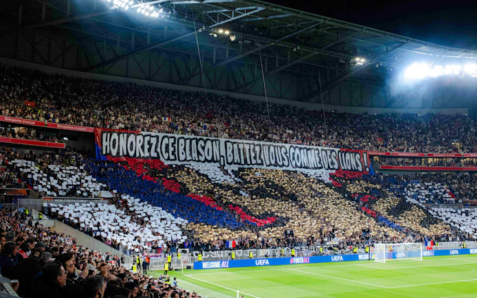 Crowd displaying a large banner at Olympique Lyonnais stadium, Lyon, France.