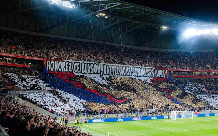 Crowd displaying a large banner at Olympique Lyonnais stadium, Lyon, France.