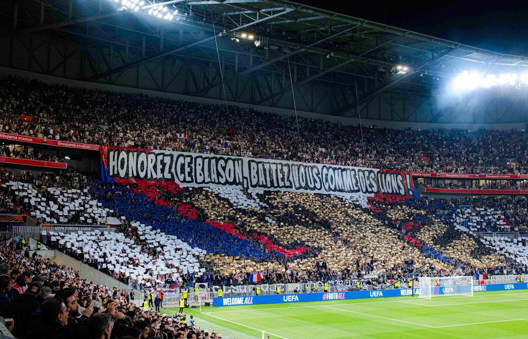 Crowd displaying a large banner at Olympique Lyonnais stadium, Lyon, France.