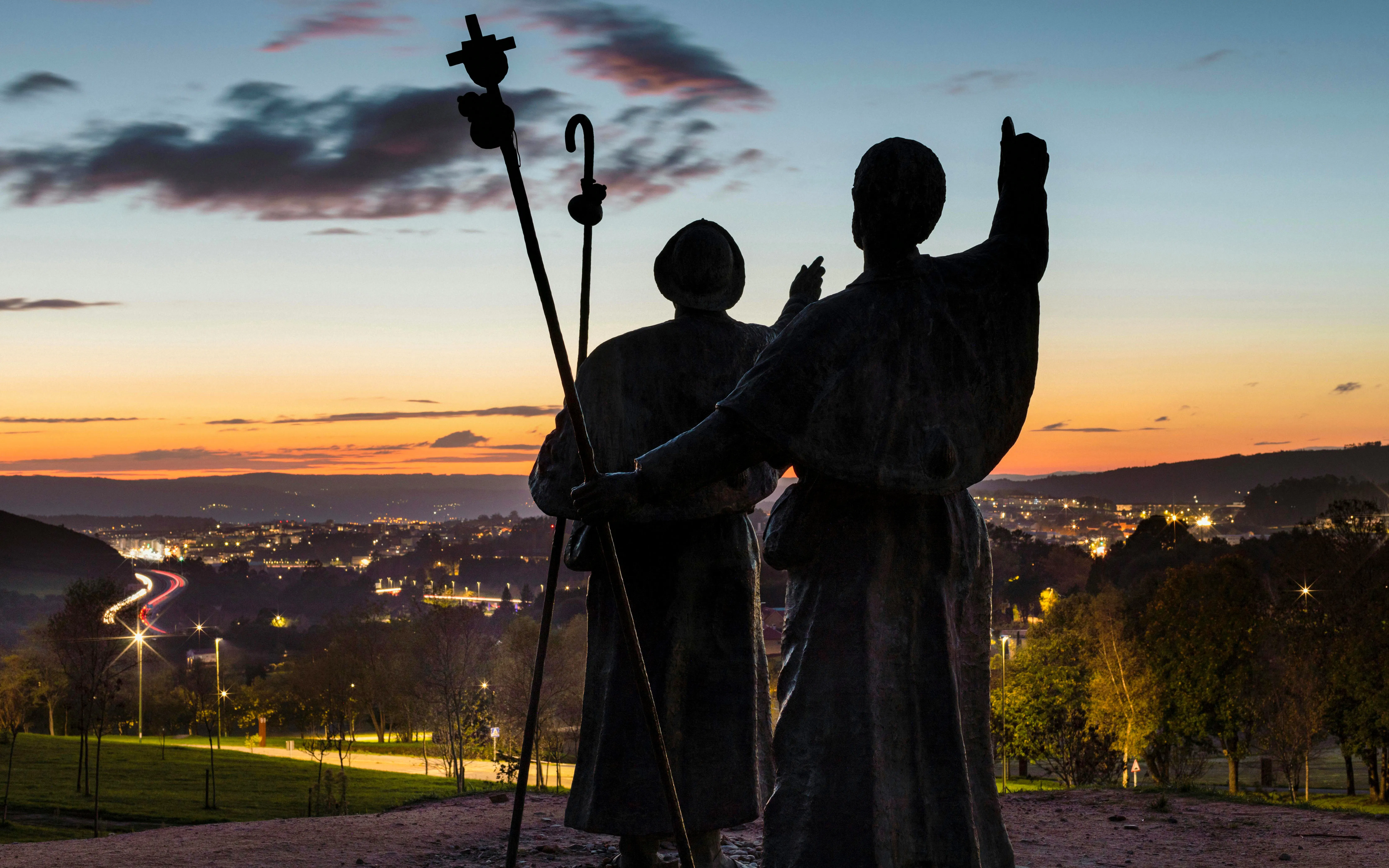Sculptures of pilgrims at Ao Caminante Monument, Monte do Gozo, Santiago de Compostela at sunset.