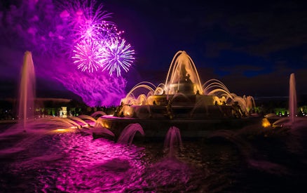 Versailles fountains illuminated with fireworks during night show from Paris.
