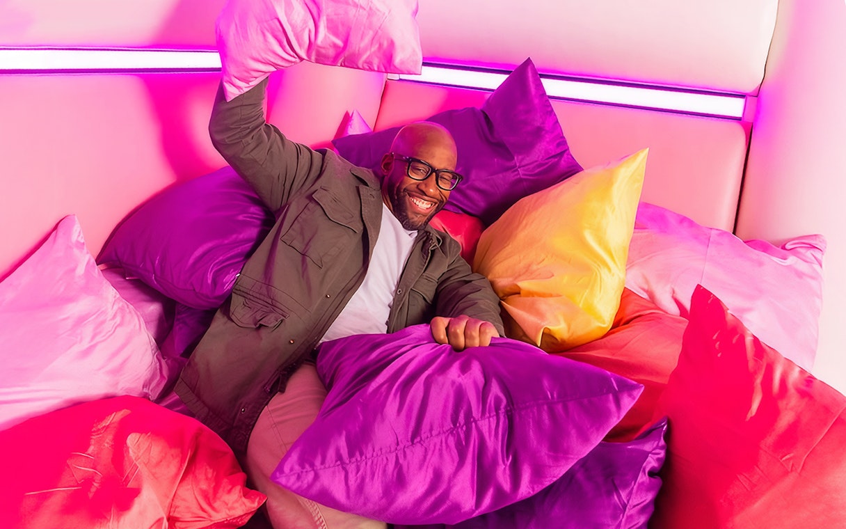 Guest enjoying colorful pillow room at Dopamine Land.