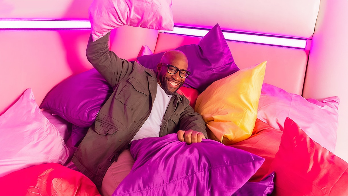 Guest enjoying colorful pillow room at Dopamine Land.