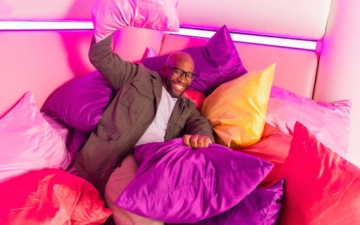 Guest enjoying colorful pillow room at Dopamine Land.