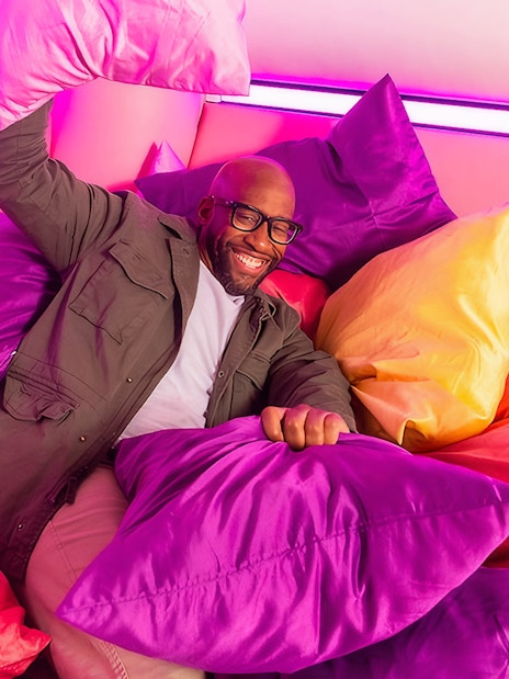 Guest enjoying colorful pillow room at Dopamine Land.