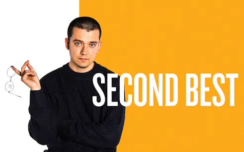 Man holding broken glasses with "Second Best" text on orange background.