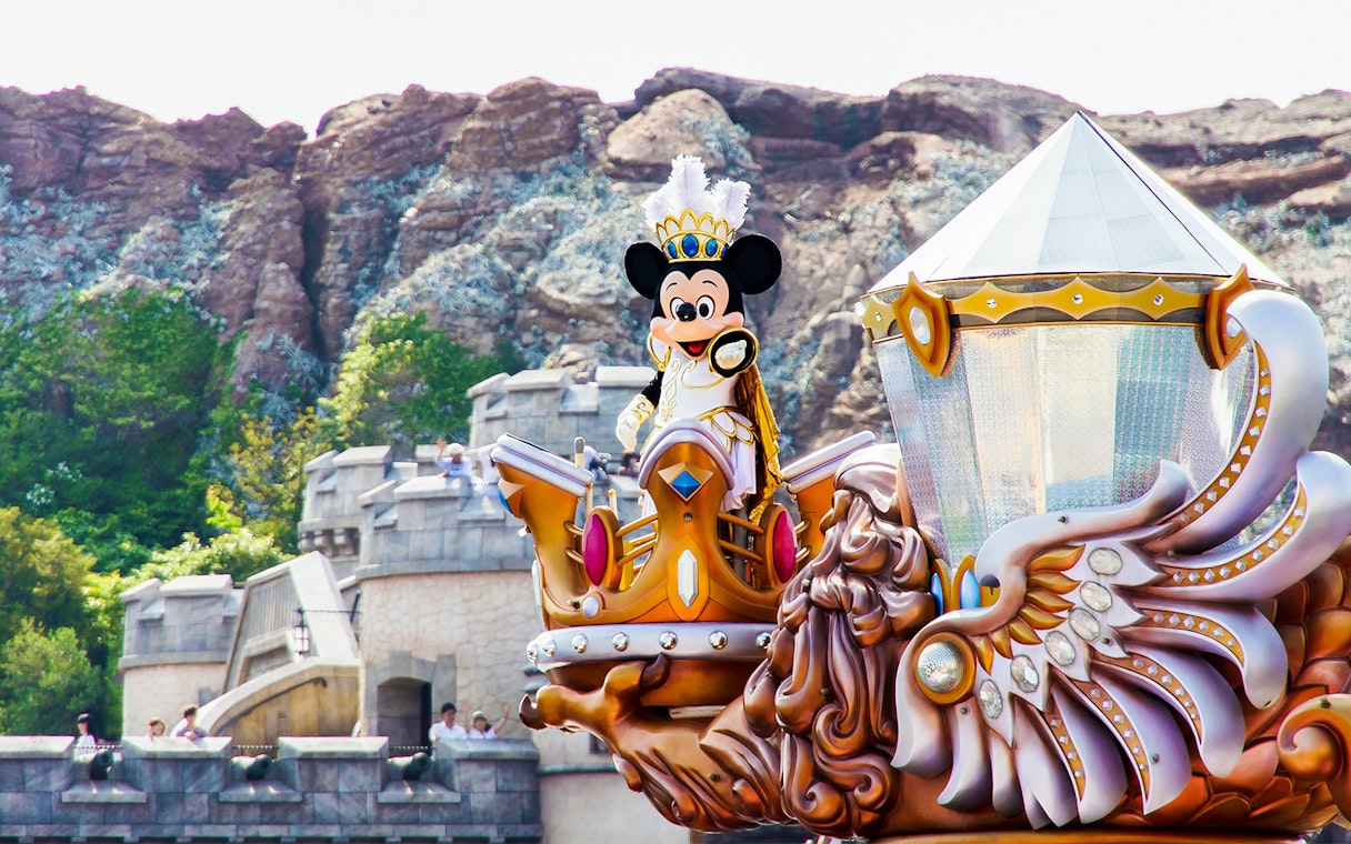 Mickey Mouse in royal attire on a parade float at Tokyo Disneyland.