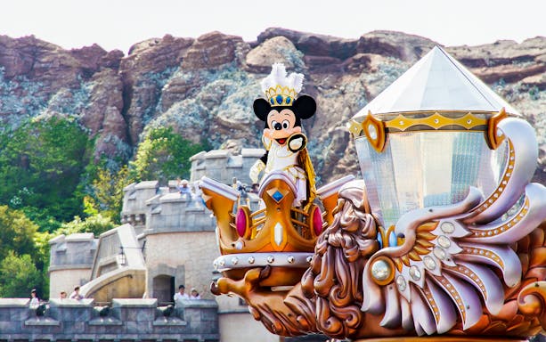 Mickey Mouse in royal attire on a parade float at Tokyo Disneyland.