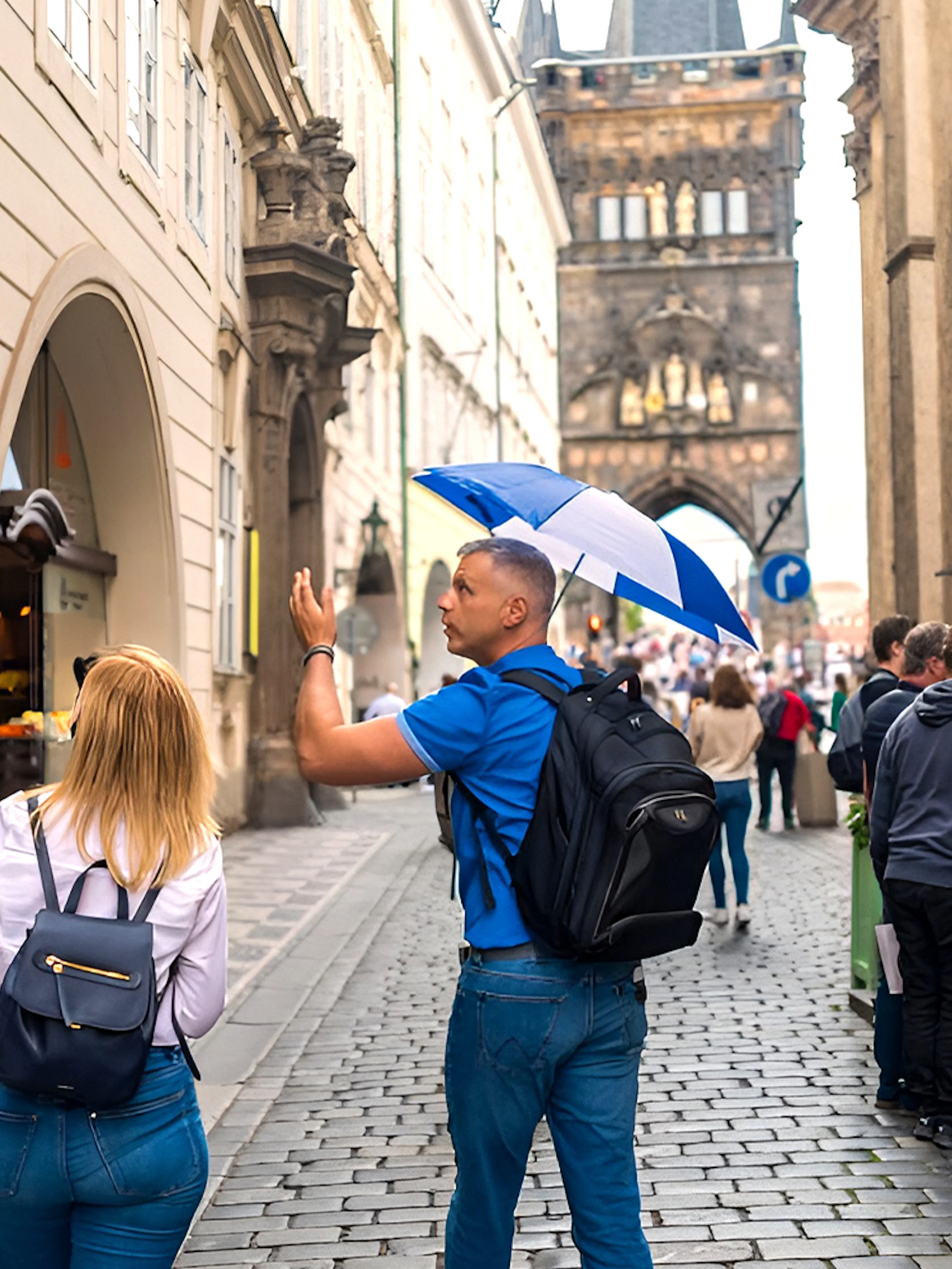 Tour guide leading a group through Prague Old Town near Charles Bridge.