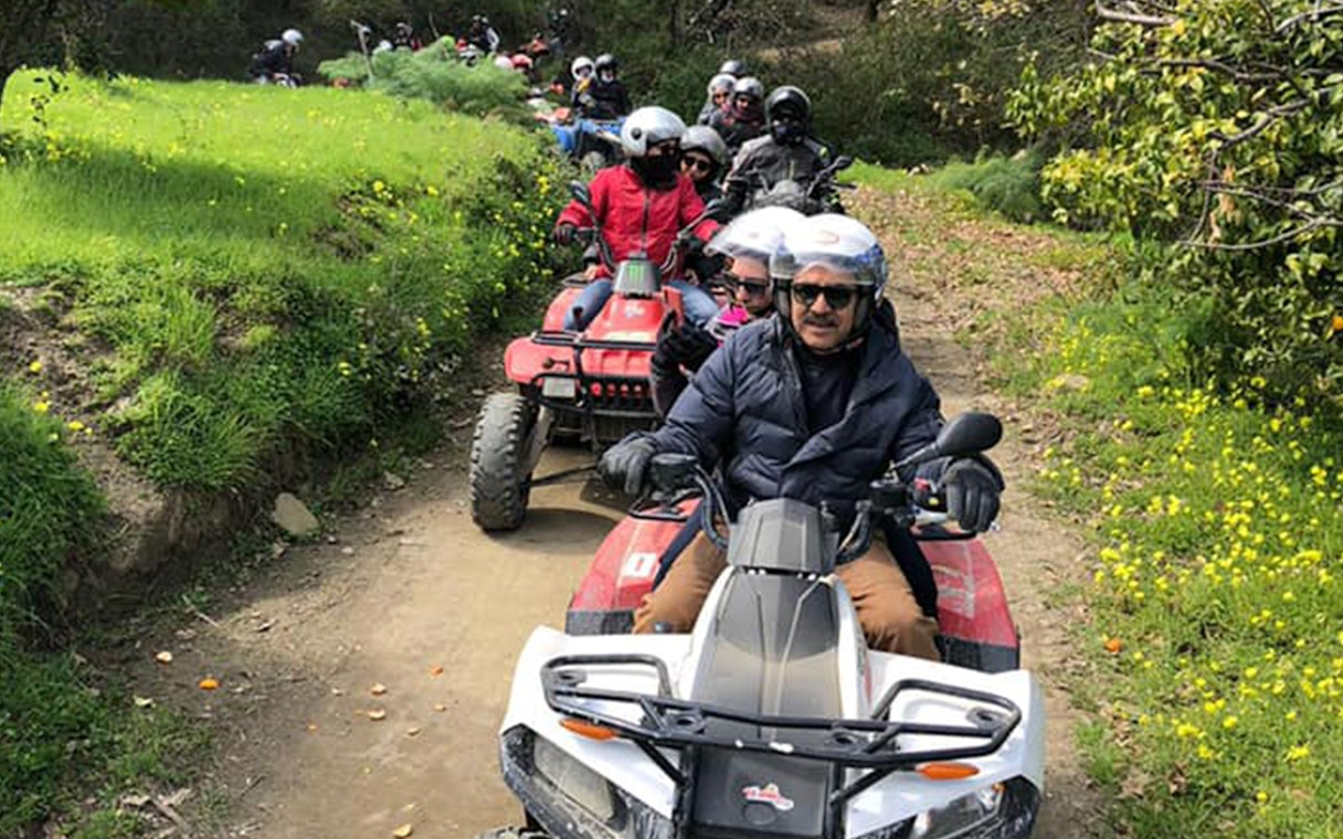 Group riding quad bikes on a trail through Alcantara Gorges, Sicily.