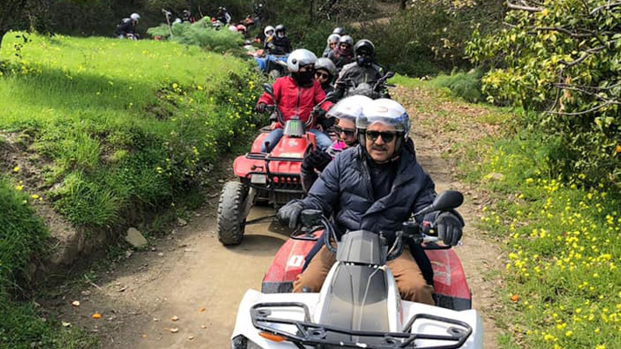 Quad bikes on rocky terrain at Alcantara Gorges, Sicily, with Mount Etna in the background.