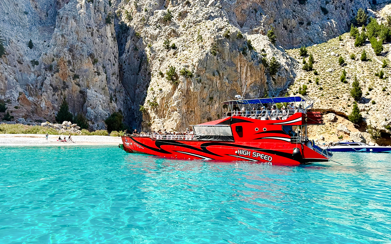 High-speed boat near rocky cliffs in St George's Bay, Rhodes.