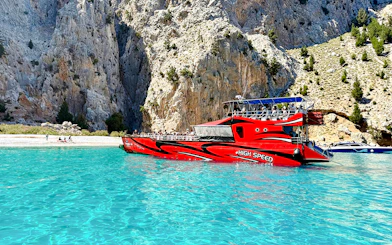 High-speed boat near rocky cliffs in St George's Bay, Rhodes.