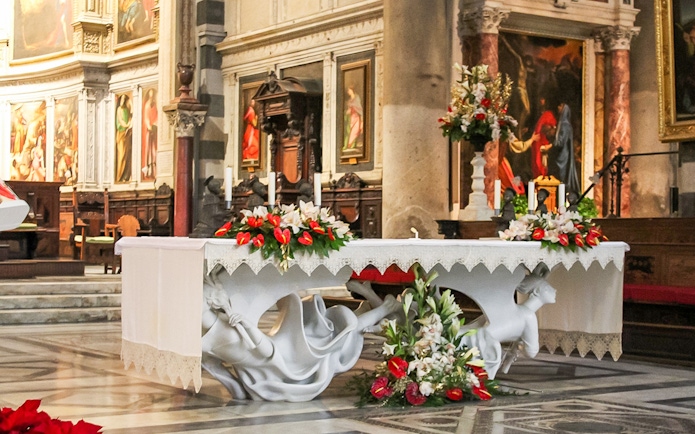 Altar inside Pisa Cathedral with ornate sculptures and floral decorations.