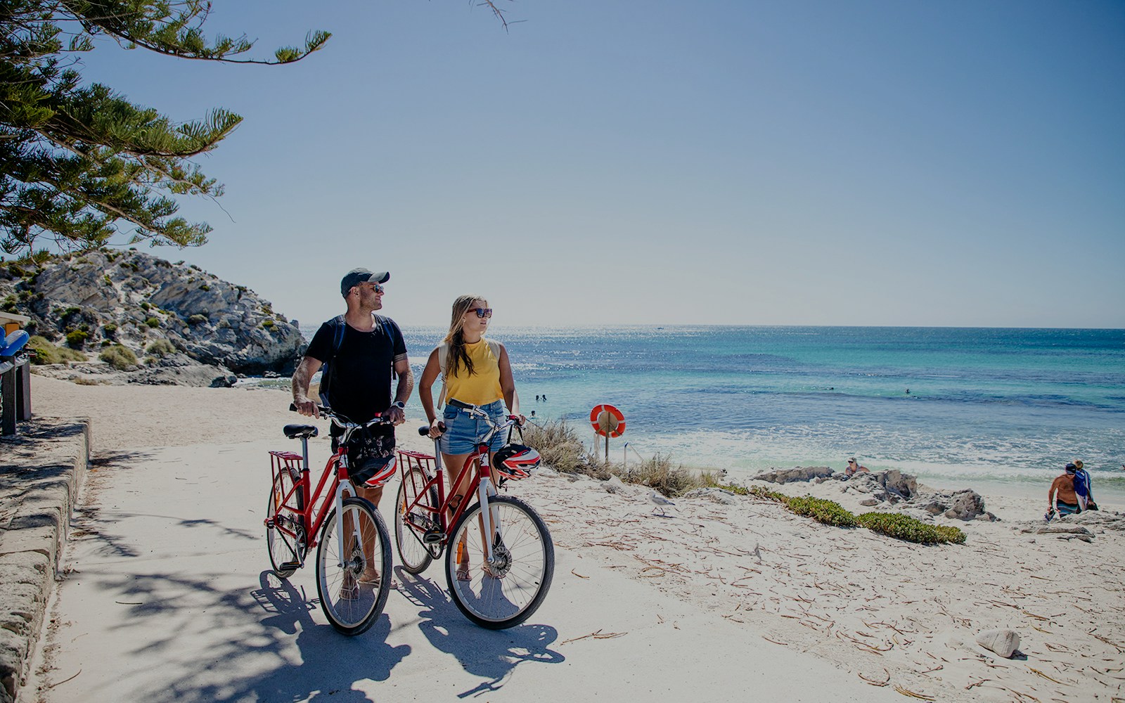 Couple with bicycles on Rottnest Island beach, Western Australia.