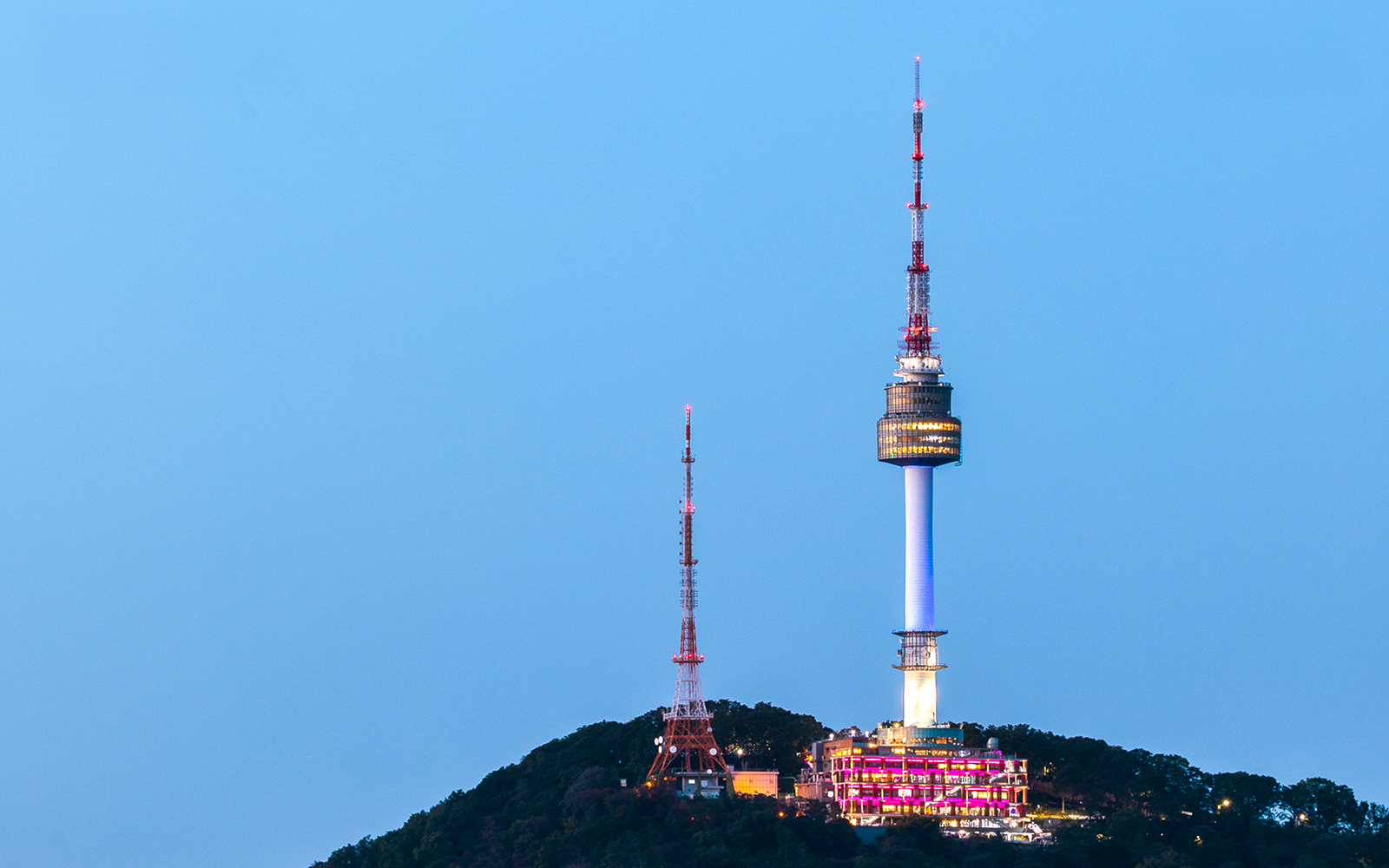 Seoul Namsan Tower illuminated at dusk with cityscape view.