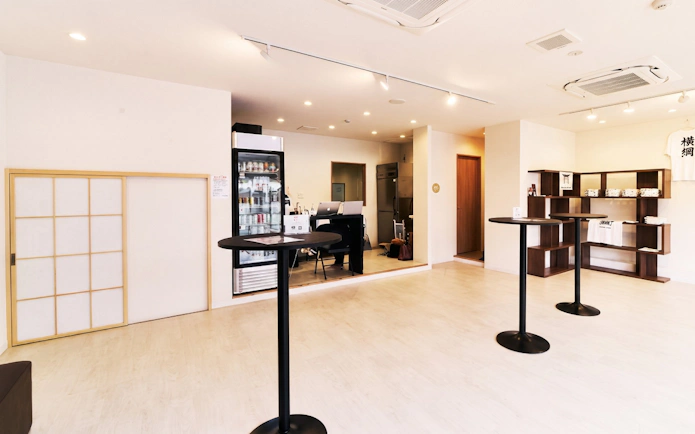 Interior of a sumo experience venue in Osaka with tables and merchandise display.