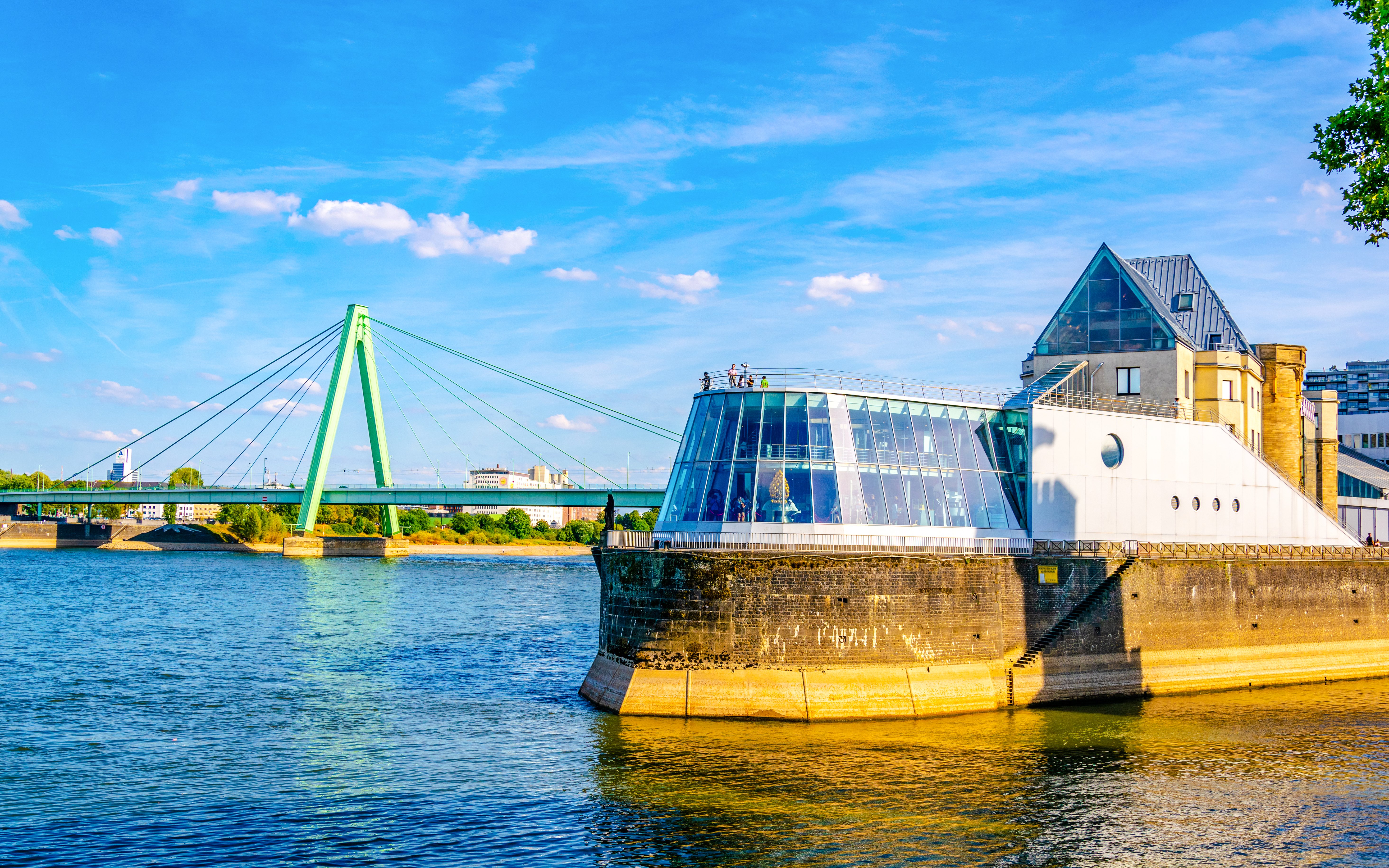 Chocolate Museum in Cologne by the Rhine River with a bridge in the background.