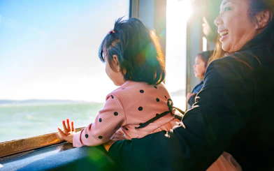 Child and adult enjoying views on San Francisco dinner cruise.