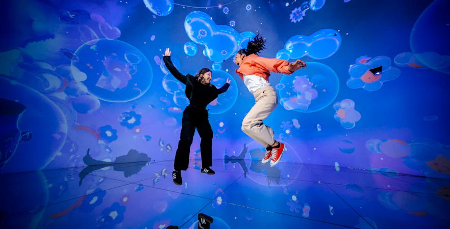 People jumping in a vibrant digital art installation at House Of Hype.