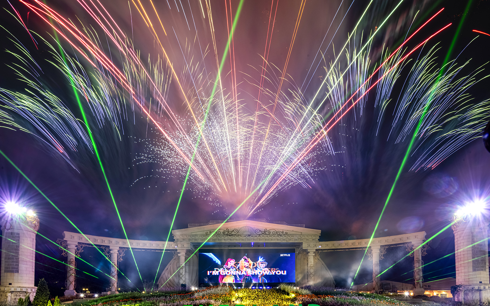 Fireworks display at K-pop demon hunters event with colorful lights and stage.