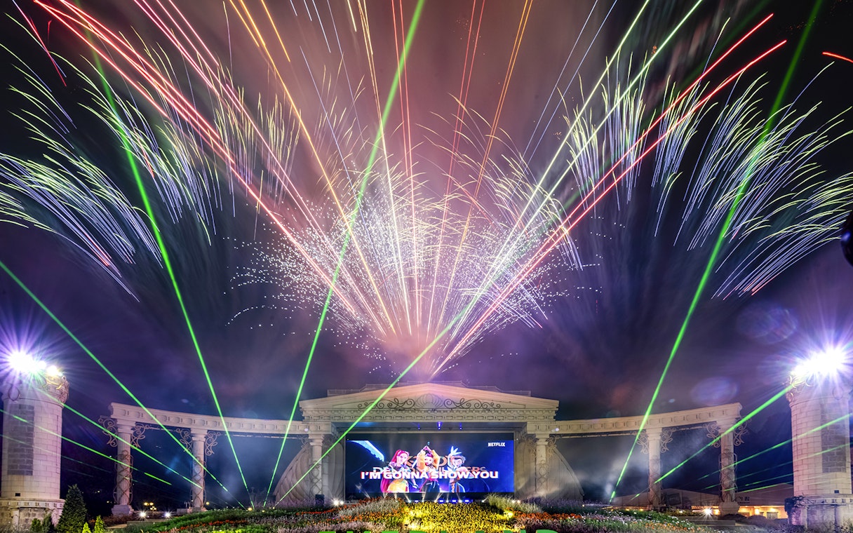 Fireworks display at K-pop demon hunters event with colorful lights and stage.
