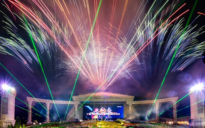 Fireworks display at K-pop demon hunters event with colorful lights and stage.