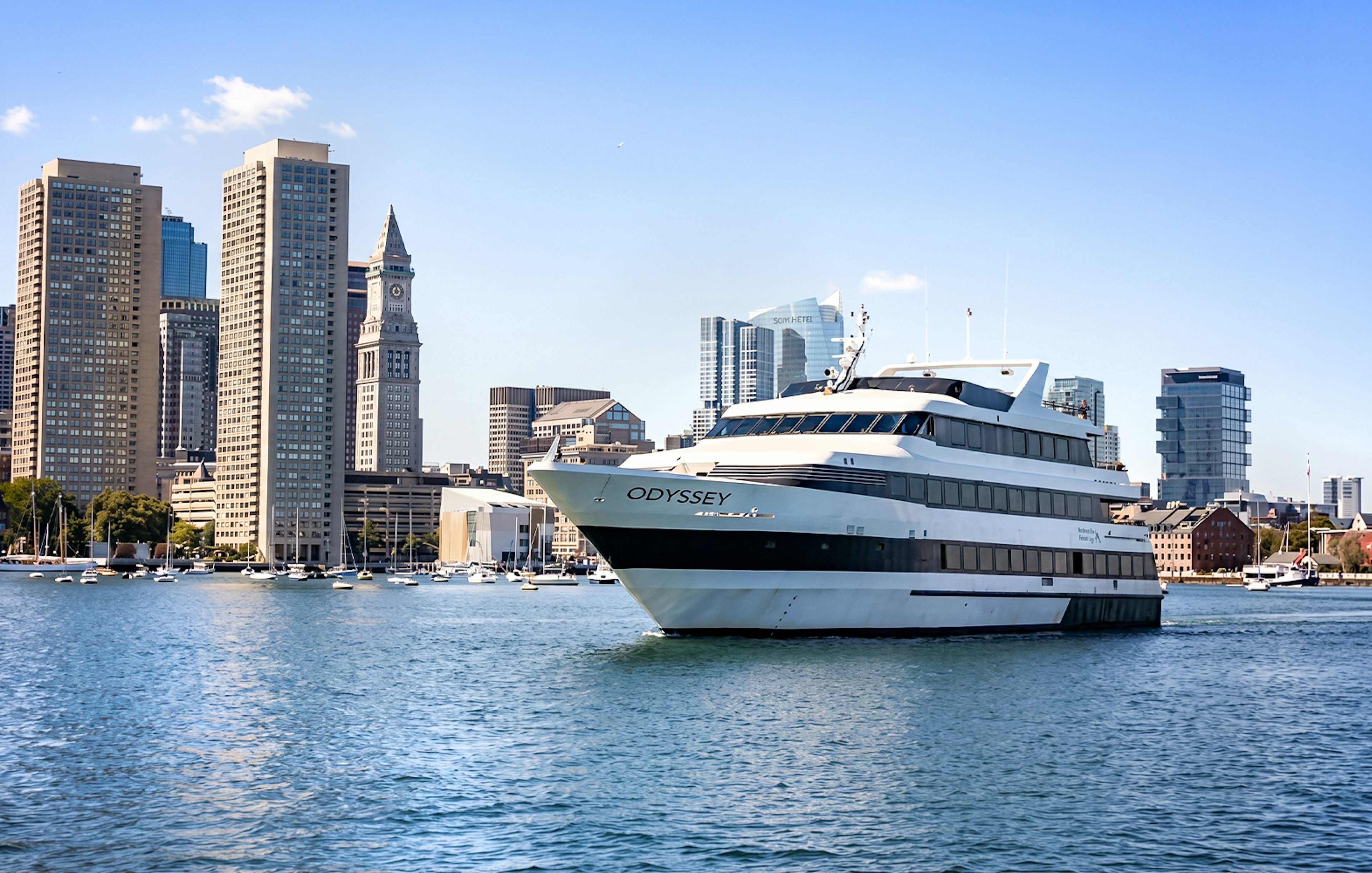 Cruise ship on Boston Harbor with city skyline in the background.