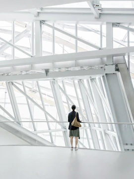 Person standing inside Fondation Louis Vuitton, Paris, viewing modern architectural design.