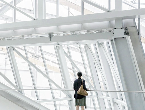 Person standing inside Fondation Louis Vuitton, Paris, viewing modern architectural design.