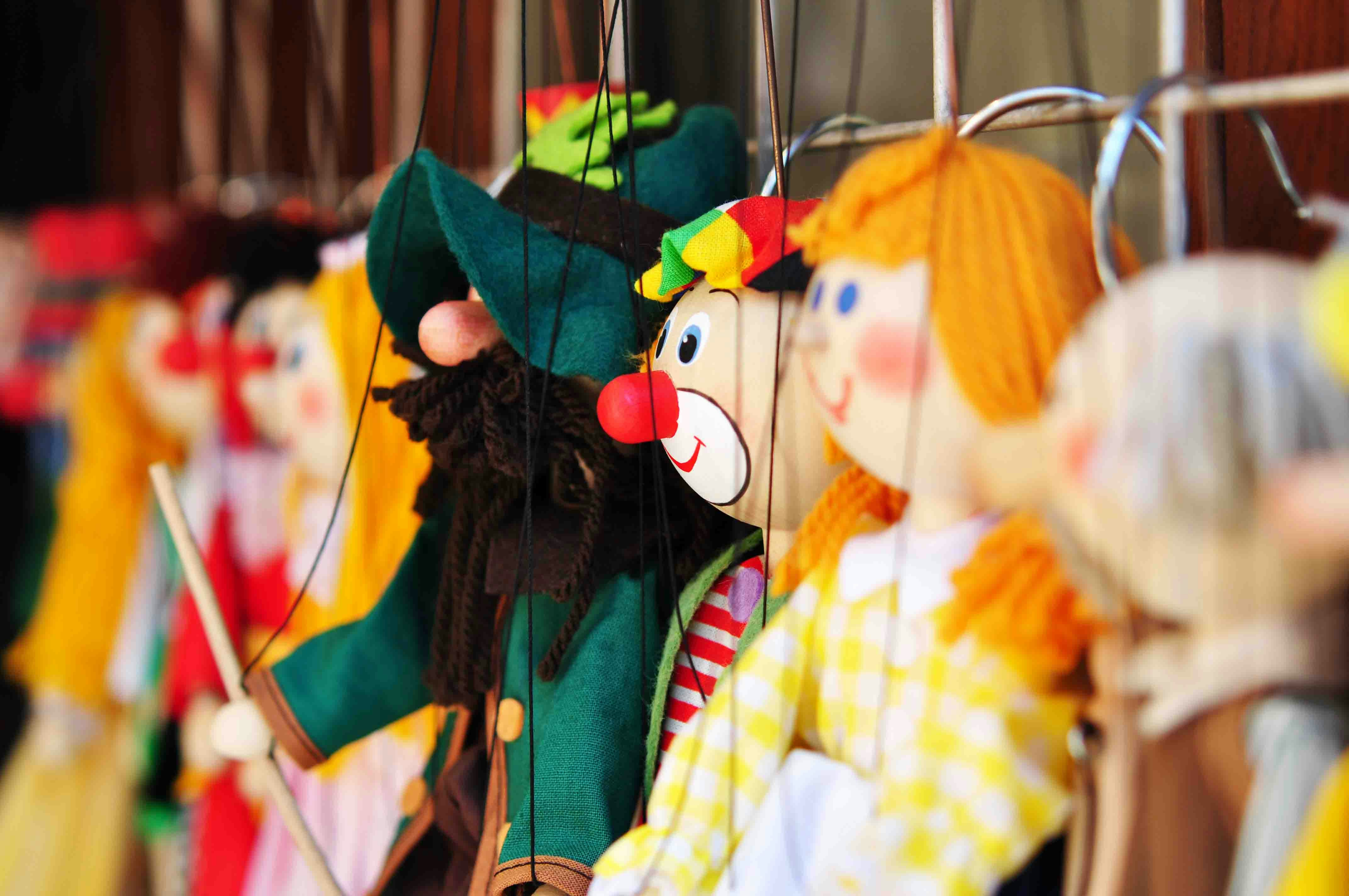 Colorful marionette puppets on display for a puppet show.