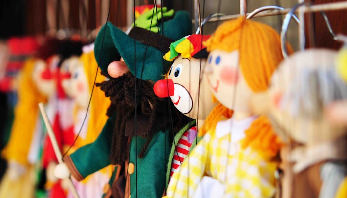Colorful marionette puppets on display for a puppet show.