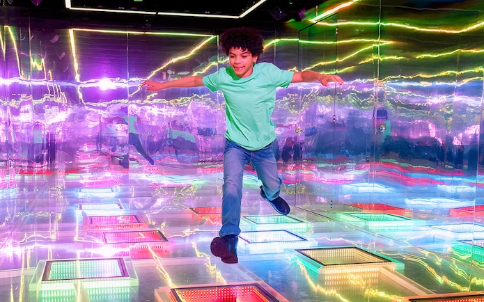 Guest exploring vibrant interactive room at Dopamine Land.