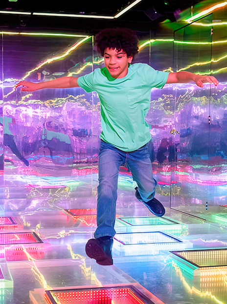 Guest exploring vibrant interactive room at Dopamine Land.