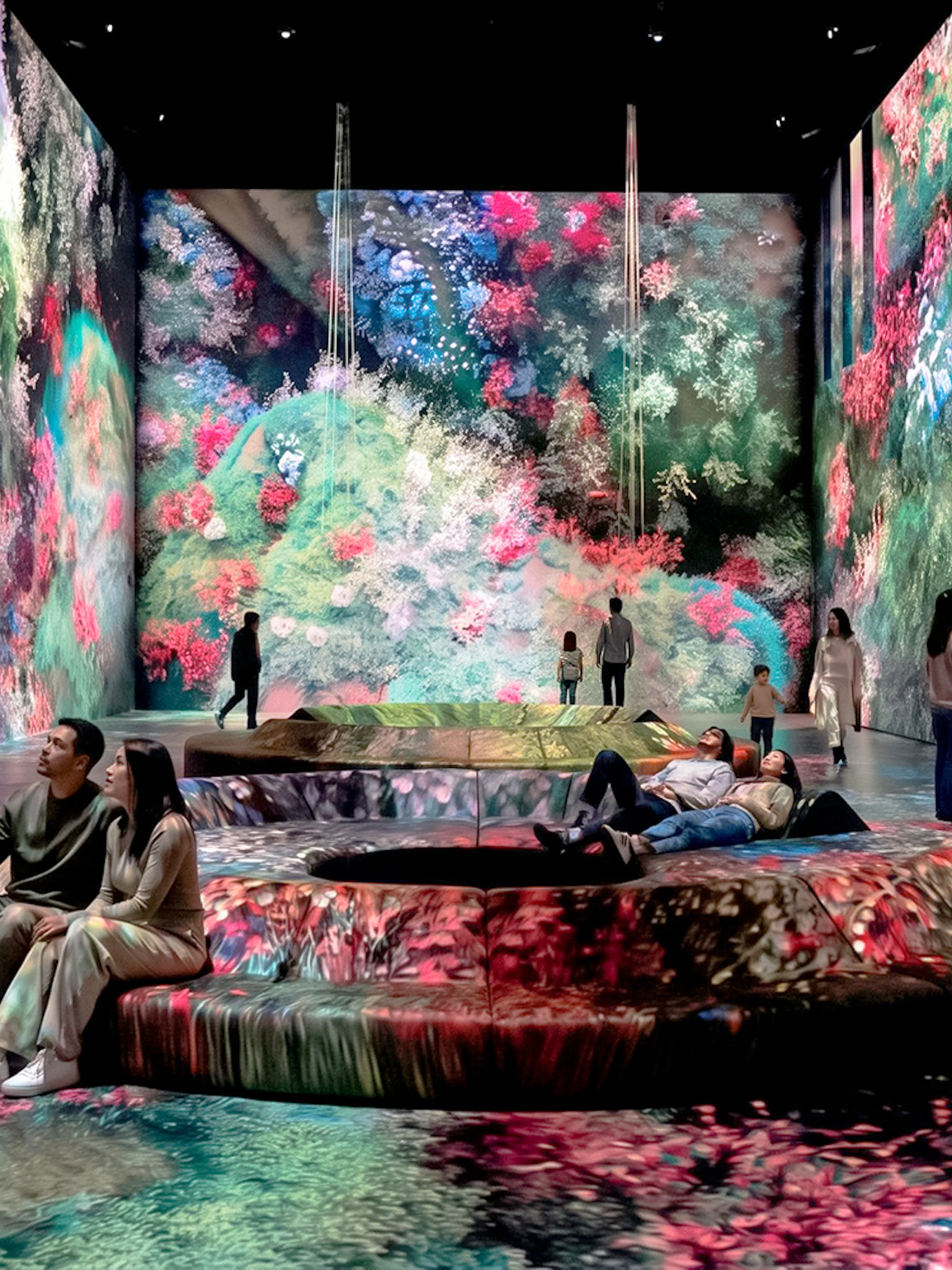 Visitors at Mercer Labs Museum of Art viewing immersive digital floral displays.