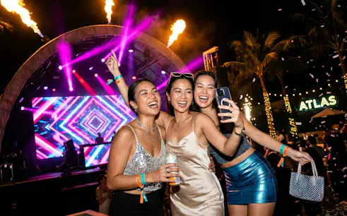 Partygoers celebrating New Year's Eve at Atlas Beach Club with live music and vibrant lights.